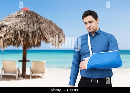 Uomo Con Braccio Rotto Sulla Spiaggia Tropicale Foto Stock