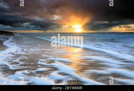 Tramonto spettacolare sulle onde del mare Nord tempestose Foto Stock