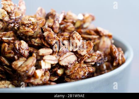 Macro shot di granola di cacao fatta in casa con arachidi croccanti e sciroppo d'acero. Luce mattutina ad alta risoluzione Foto Stock
