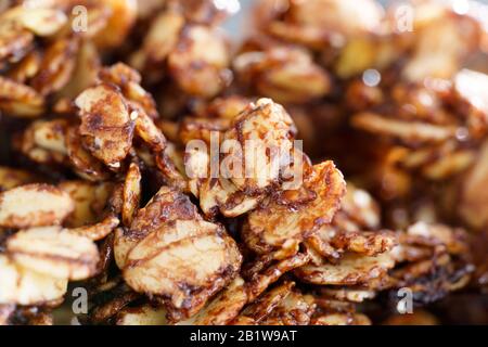 Macro shot di granola di cacao fatta in casa con arachidi croccanti e sciroppo d'acero. Luce mattutina ad alta risoluzione Foto Stock