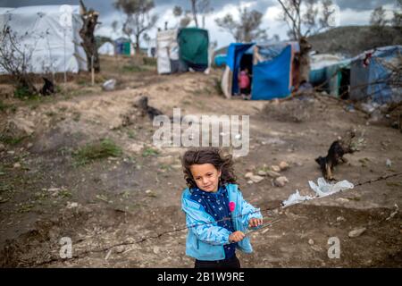 Lesbo, Grecia. 27th Feb, 2020. Una bambina sta accanto alla recinzione di filo spinato in un campo di tenda temporaneo vicino al campo per i migranti a Moria. A seguito di gravi scontri tra polizia e abitanti arrabbiati dell'isola greca di Lesbo, che ha lasciato decine di feriti, il primo ministro Mitsotakis ha ordinato alla polizia antisommossa di ritirarsi dalle isole. Credito: Angelos Tzortzinis/Dpa/Dpa/Alamy Live News Foto Stock