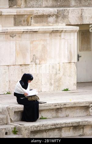 Donna che legge ad Amman - Giordania Foto Stock