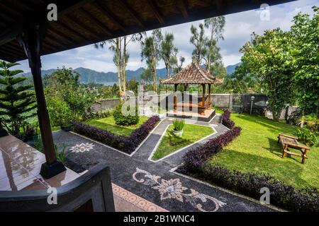 Giardino tropicale paesaggistico con padiglione al Mapa Lakeview Bungalow sulle pendici del Monte Batur, Bali, Indonesia Foto Stock