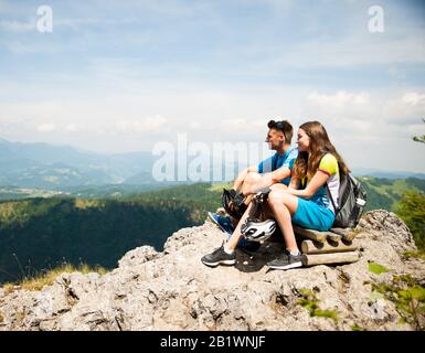 Una coppia attiva si riposa dopo aver fatto un giro in bicicletta su una cima di montagna Foto Stock