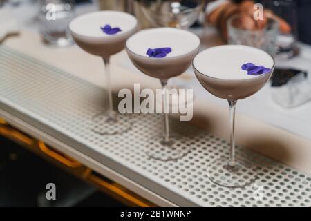 Bei cocktail da caffè decorati con petali di fiori violacei Foto Stock
