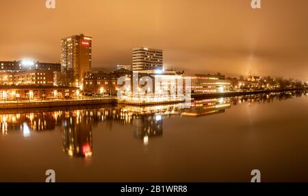 Panorama, vista nebbiosa dal ponte centrale sul fiume alla città centrale di Umea, comune di Vasterbotten, Svezia Foto Stock