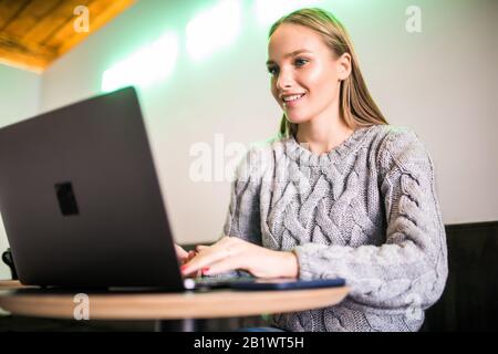 Giovane donna guardando il computer portatile Foto Stock