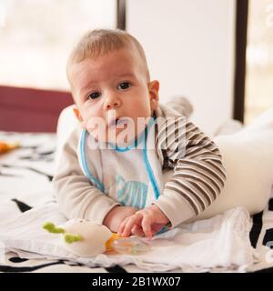 bambino di 3 mesi gioca con i suoi giocattoli e guarda la fotocamera Foto Stock