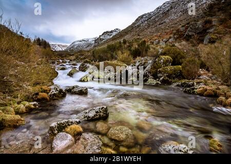 Prospettiva sul fiume Zêzere in una giornata innevata in vale Glaciar do Zêzere, la più grande valle glaciale in U forma d'Europa si trova a Serra da Estrela Foto Stock