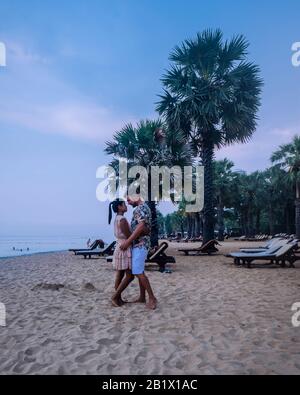 NaJomtien Pattaya Thailandia, coppia di uomini e donne a piedi sulla spiaggia durante l'alba a Pattaya Thailandia Foto Stock