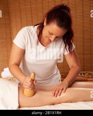 Bella giovane donna che ha un trattamento di massaggio di maderoterapia in salone di spa - benessere Foto Stock