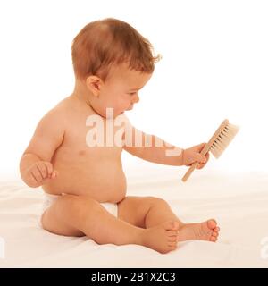 Bambino hapy nel gioco sul letto isolato su bianco Foto Stock