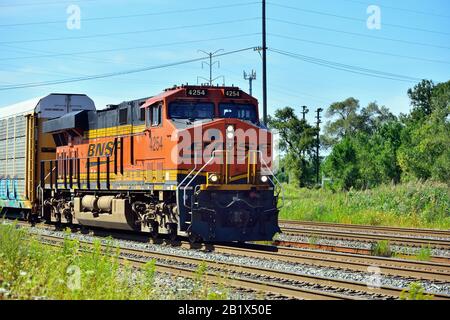 Dalton, Illinois, Stati Uniti. Un treno di trasporto a cremagliera auto del nord di Santa Fe di Burlington che si muove su un percorso multi-pista occupato. Foto Stock