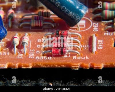 Una macro foto di una tipica scheda elettronica che mostra diodi, resistori e condensatori. Foto Stock