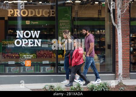 Un gruppo di amici cammina lungo Pike Street di fronte ad Amazon Go Grocery il 27 febbraio 2020. Il primo supermercato cashierless di dimensioni standard della società tecnologica è stato inaugurato nel quartiere Capitol Hill di Seattle all’inizio della settimana. I clienti eseguono la scansione di un'app Amazon Go per accedere al negozio di 10.000 piedi quadrati, prendere i prodotti e andare senza effettuare il check-out. La "Just Walk Out Technology" di Amazon utilizza un sistema complesso di telecamere e sensori per tenere traccia degli acquisti già in uso nei loro piccoli negozi Amazon Go. Foto Stock