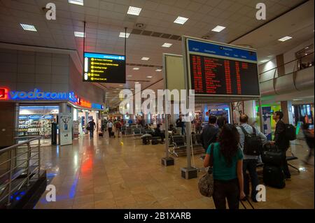 Viaggiatori che controllano i voli presso l'area Duty Free Shop dell'Aeroporto Internazionale R. Tambo, Johannesburg, Sud Africa Foto Stock