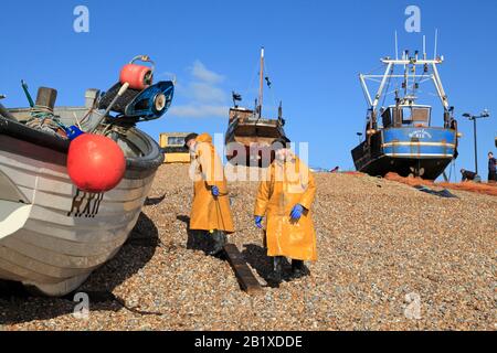 I pescatori di Hastings sbarcano la loro barca da pesca sulla spiaggia Dei Pescatori del centro storico di Stade a Rock-a-Nore, East Sussex , Regno Unito, GB Foto Stock