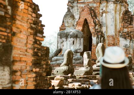 Un turista che esplora il Parco storico di Ayutthaya (fuoco sullo sfondo) che è una delle destinazioni culturali famose di viaggio in Thailandia Foto Stock