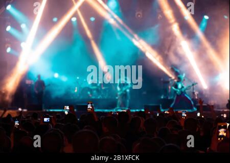 Gli appassionati di musica registrano video al telefono in folla durante il festival dei concerti. Foto Stock