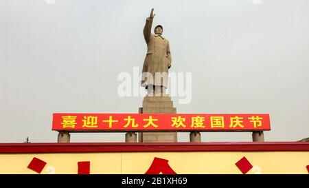 Statua di Mao Zedong presso la Piazza Del Popolo di Kashgar. I personaggi cinesi qui sotto leggano 'Benvenuti al congresso nazionale 19th' posa Tipica per Mao Foto Stock