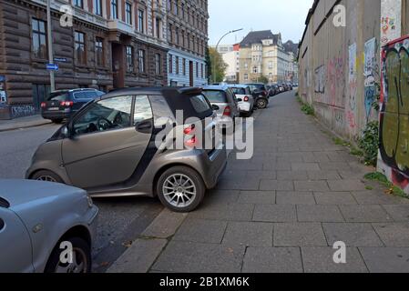 Smart Car Fortwo parcheggiava lateralmente con le ruote sul marciapiede in un parcheggio su strada ad Amburgo, in Germania. Ottobre 2019 Foto Stock