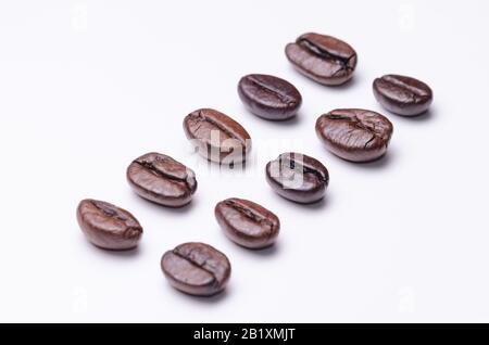 Chicchi di caffè, caffè arabica, organizzazione allineata all'ordine, tostati, macro-close-up still life, isolati su sfondo bianco, vista dall'alto, interni Foto Stock