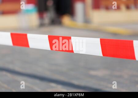 Nastro barriera a strisce rosse e bianche/isolato, con sfondo sfocato. Foto Stock