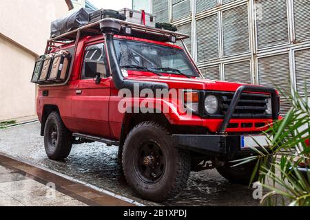 Primo piano della jeep sporca. In piedi su strada di pietra. Foto Stock