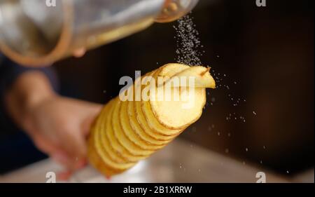 tornado potatoe su un bastone che viene salato in un negozio di cibo Foto Stock