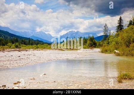 Vista sul letto parzialmente asciutto del fiume Isar in estate, Alpi Bavaresi, Baviera, Germania, verso le montagne Wetterstein Foto Stock