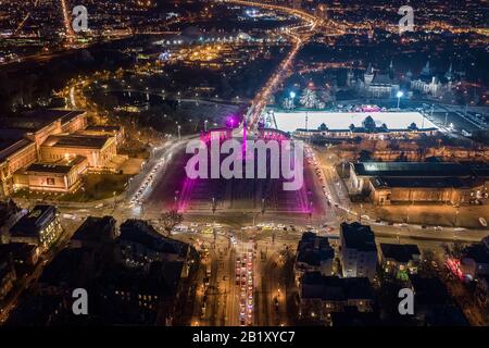 Budapest, Ungheria - veduta aerea del drone della famosa Piazza degli Eroi (Hosok tere) illuminata da luci viola e rosa uniche di notte Vajdahunyad Castello A. Foto Stock