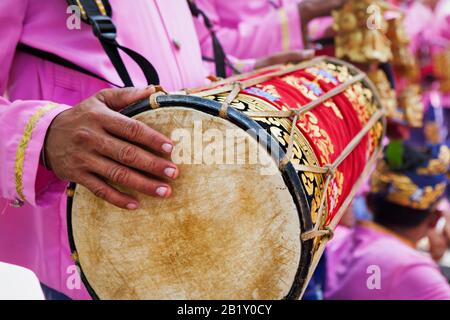 L'uomo balinese suona musica sul tradizionale drum Kendang - musicisti dell'orchestra Baleganjur (Gamelan). Festival di arte in Indonesia, cultura di Bali Foto Stock