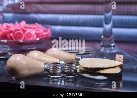 Tailor's Table con Attrezzi Assortiti tra cui punteruolo, ditali, bottoni e gesso Foto Stock