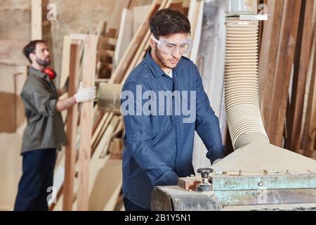 Carpentiere lavora su una pialla in una Falegnameria Foto Stock