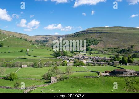 Vista estiva del villaggio di Yorkshire Dales di Muker a Swaledale, circondato da un paesaggio classico dello Yorkshire di prati e brughiere Foto Stock