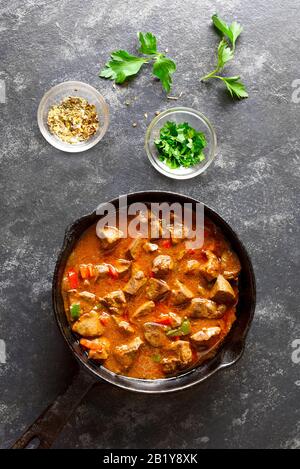 Peri-peri fegati di pollo in padella su fondo di pietra nera. Vista dall'alto, piatto Foto Stock