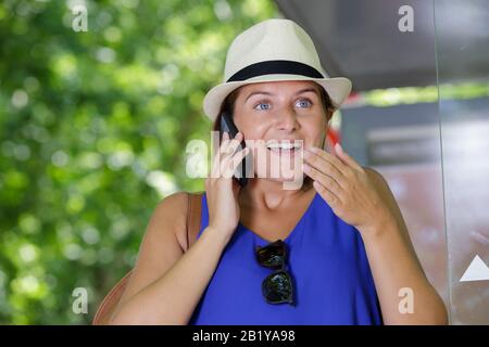 donna al telefono con cappello Foto Stock