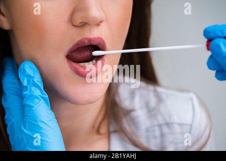 Vista posteriore di un medico di sesso maschile prendendo un fluido corporeo campione per il test del DNA Foto Stock