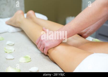 massaggiatore che massaggia le spalle delle gambe di un donna Foto Stock