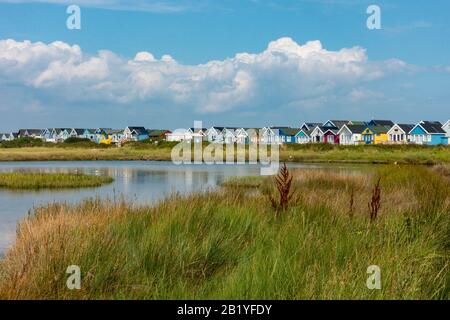 Beach Huts Su Hengistbury Head Sandspit, Affacciato Sulla Laguna Di Holloways Dock E La Riserva Naturale. Foto Stock