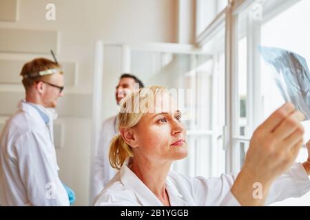 Gruppo di medici lavora in ospedale e guarda un radiografico Foto Stock