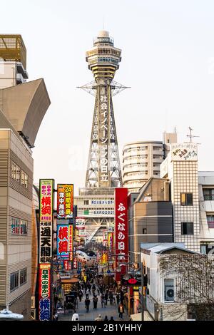 Vista dall'alto dell'ora dorata lungo la zona pedonale della famosa Torre Tsutenkaku che torreggia sul quartiere dei divertimenti chiamato Shinsekai di Osaka Foto Stock