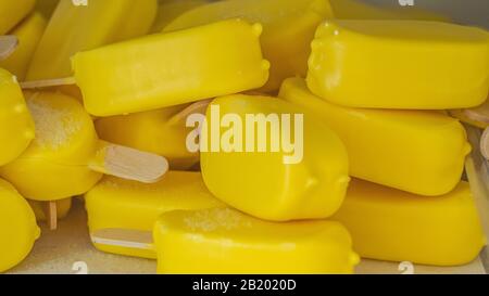 piccoli gelati gialli con bastoncini Foto Stock