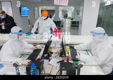 Wuhan, Provincia Di Hubei, Cina. 28th Feb 2020. (200228) -- WUHAN, 28 febbraio 2020 (Xinhua) -- Yu Guoqiao (2nd R), fisicamente disabilitato, gestisce le procedure di assunzione di medicinali per i pazienti disabili di una comunità in un negozio di farmaci a Wuhan, nella provincia centrale cinese di Hubei, 27 febbraio 2020. Yu Guoqiao è un facilitatore di un gruppo di disabili in una comunità nel distretto di Hanyang del Wuhan coronavirus-hit. Dallo scoppio del virus, Yu ha superato le difficoltà di assumere con insistenza medicinali per i quasi 300 pazienti disabili della comunità. Credito: Xinhua/Alamy Live News Foto Stock