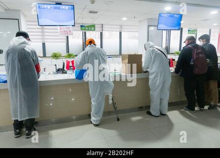 Wuhan, Provincia Di Hubei, Cina. 28th Feb 2020. (200228) -- WUHAN, 28 febbraio 2020 (Xinhua) -- Yu Guoqiao (2nd L), fisicamente disabilitato, gestisce le procedure di assunzione di medicinali per i pazienti disabili di una comunità in un negozio di farmaci a Wuhan, nella provincia centrale cinese di Hubei, 27 febbraio 2020. Yu Guoqiao è un facilitatore di un gruppo di disabili in una comunità nel distretto di Hanyang del Wuhan coronavirus-hit. Dallo scoppio del virus, Yu ha superato le difficoltà di assumere con insistenza medicinali per i quasi 300 pazienti disabili della comunità. Credito: Xinhua/Alamy Live News Foto Stock