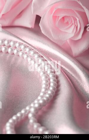 Perline di perle e crema rosa sulla seta Foto Stock
