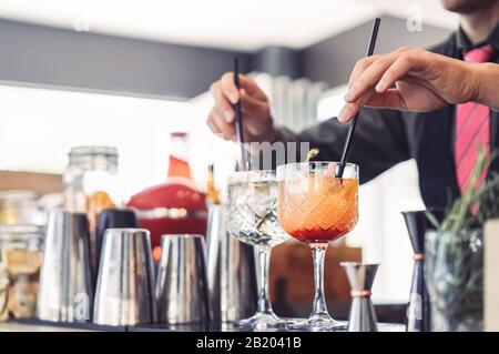 Il barman prepara i cocktail nel bar dell'intrattenimento - Il Barman mescola i drink e serve i clienti in discoteca Foto Stock