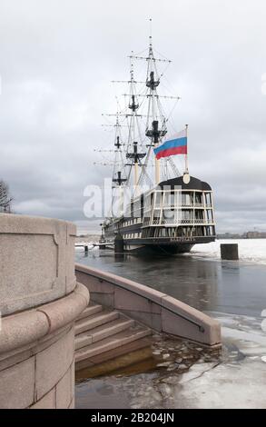 San Pietroburgo, Russia – 13 febbraio 2020: La fregata con bandiera russa sul fiume Neva vicino all'Embankment Petrovskaya nel giorno delle inondazioni invernali Foto Stock