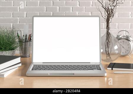 Area di lavoro con monitor per laptop vuoto, schermo bianco, modellato sulla scrivania in legno vicino a una parete di mattoni bianchi Foto Stock