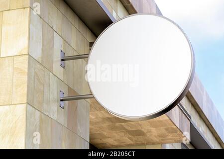 Cartellone rotondo o cartellonistica sulla parete di marmo con mock up di un cartello bianco bianco. Vista dal basso Foto Stock